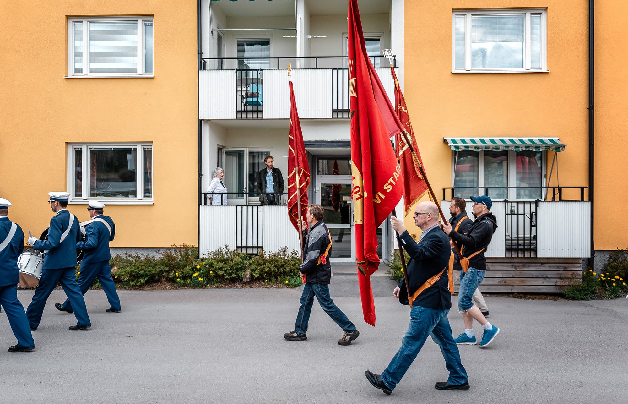 Demonstrationståg går förbi balkong där Vera Oredsson iakttar det