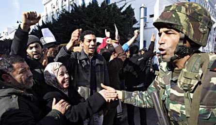 Demonstranter och soldater möttes under protester mot Tunisiens förre president Ben Ali. Foto: AP