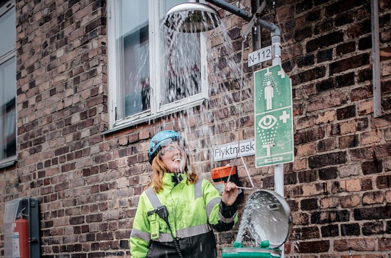 Emma Davidsson testar nödduschen vid ”Ättikan” – där en gång Perstorpsättikan tillverkades. Halva dagen sitter processoperatörerna i kontrollrummet, andra halvan är de ute i tillverkningen. Foto: David Lundmark
