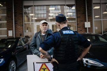 K-G Wanngård från Promenader mot strejkbryteri samtalar med polisen. Foto: David Lundmark