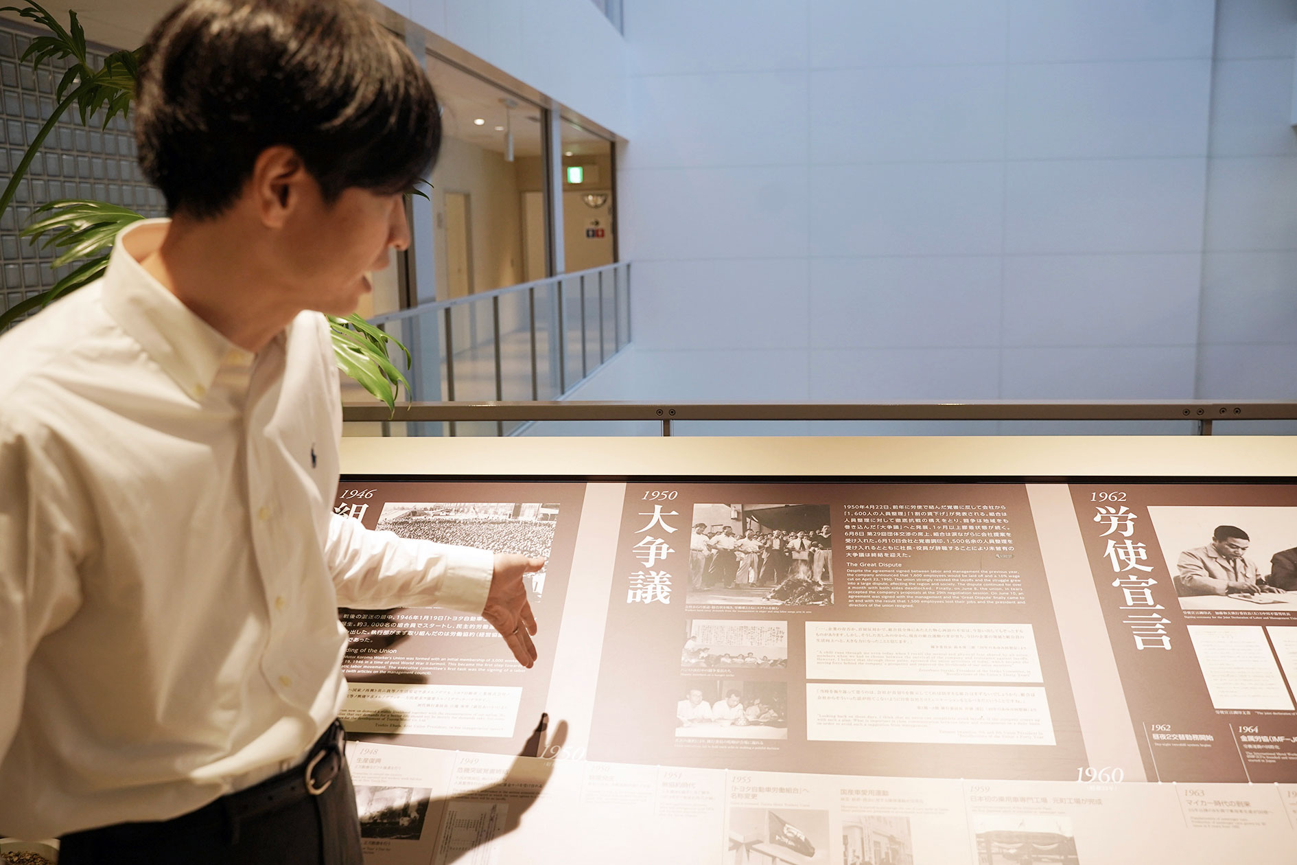 Keisuke Eshita visar raden av skyltar som berättar Toyotafackets historia. Foto: Peter Schwartz