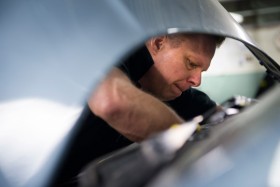 Robert Lennmark servar en Saab i verkstaden. Utvecklingen med fler större bilar påverkar bilreparatörernas arbetsmiljö. Hjälpmedel fungerar sämre och arbetställningarna blir annorlunda.  Foto: ANDERS G WARNE